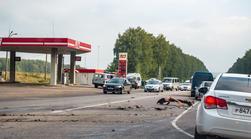 Restes d’un accident de trànsit a la carretera, amb vehicles aturats davant d’una benzinera.